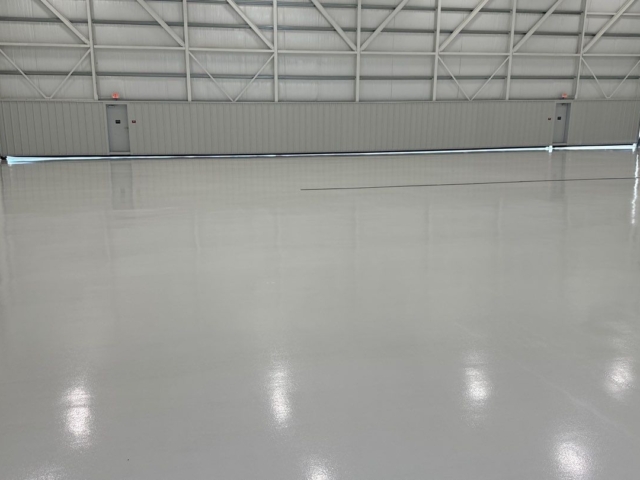 Finished epoxy flooring coatings installed photo facing hangar door