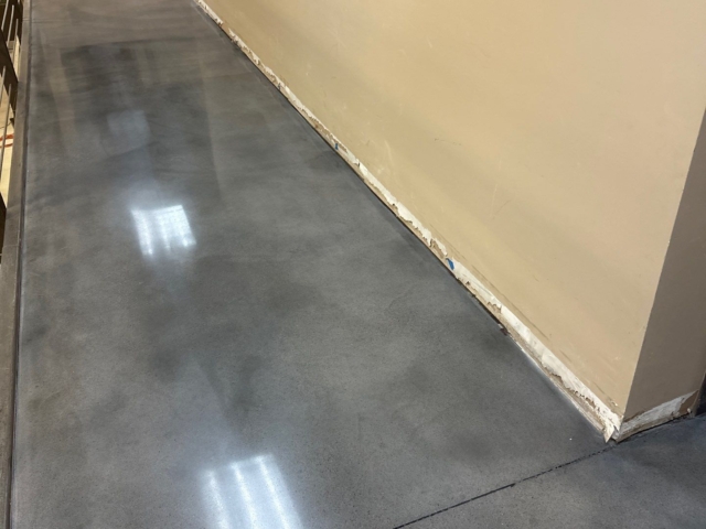 At a multi-state equipment dealer location, our team removed nearly 9,000 square feet of deteriorated coating, then made structural and cosmetic repairs before dyeing and polishing the concrete to a medium-high gloss finish.