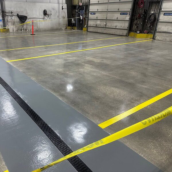 IA removed the existing worn coatings and carefully caulked all control joints to protect the integrity of the slab. The repair areas were ground and polished to restore a durable, low maintenance surface built for long term performance. To enhance safety and traffic flow, epoxy line striping was installed throughout the facility.  IA also completed a major trench drain restoration. 
