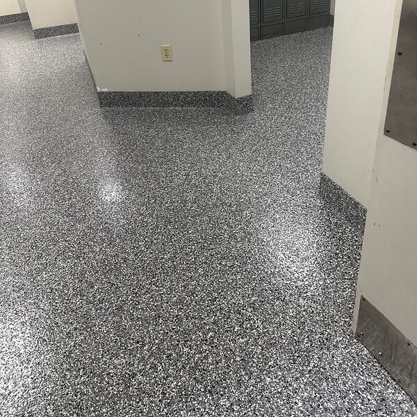 Busy automotive parts manufacturer, focused on employee satisfaction and maintaining a professional environment, called on IA crews to install a decorative flake system in the office restrooms, complete with a 6 inch hand troweled integral cove base for a clean, seamless finish