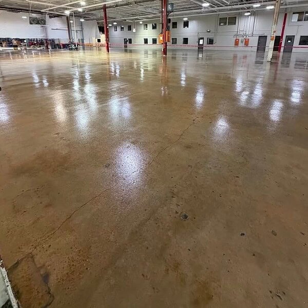 TeamIA meticulously prepared 135,000 SF of existing concrete, completing the necessary repairs and patching before installing a two-coat clear epoxy flooring system